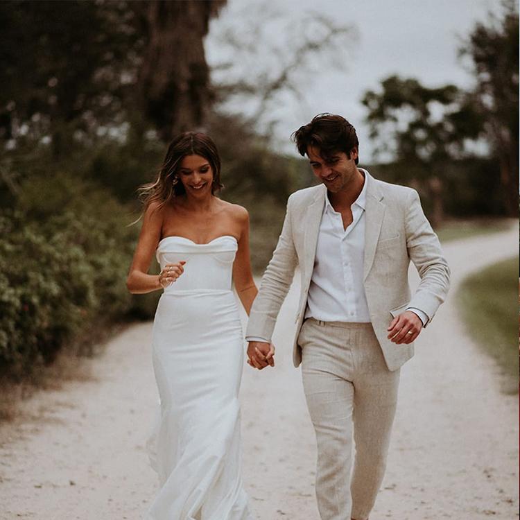 A couple on their wedding day, the groom in a custom cream linen suit