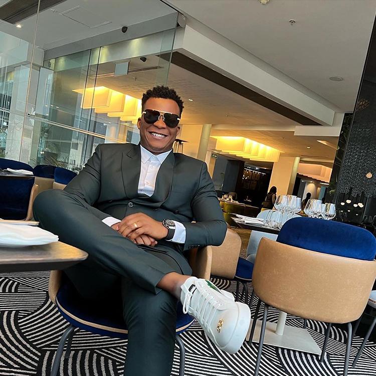 A client relaxing in a charcoal green custom suit